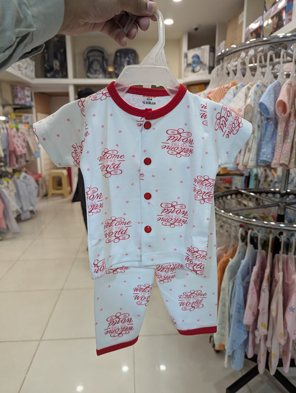 Baby onesie with red text on a hanger in a store setting