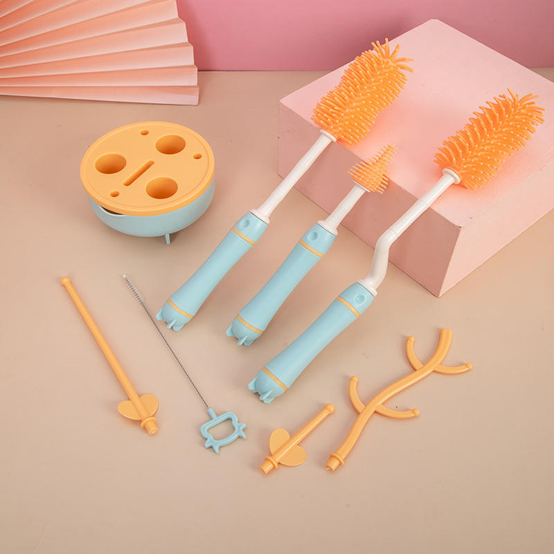 Set of baby bottle cleaning tools including brushes and a sponge on a beige background.